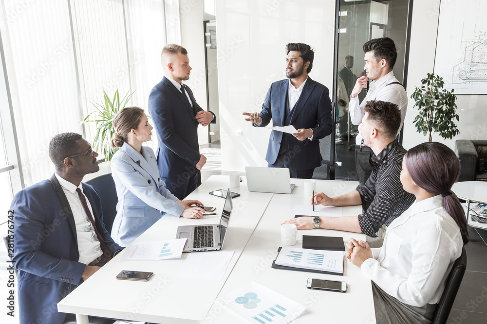 A team of young businessmen working and communicating together in an office. Corporate businessteam and manager in a meeting. A team of young businessmen working and communicating together in an office. Corporate businessteam and manager in a meeting.