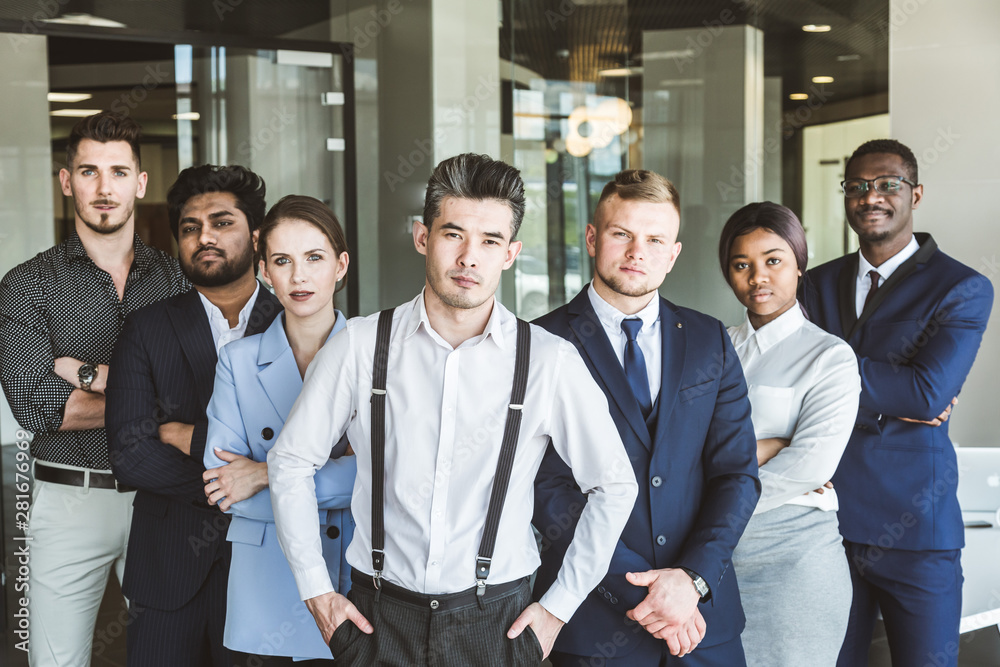 A team of young businessmen stand shoulder to shoulder, working and communicating together in an office. Corporate businessteam and manager in a meeting. A team of young businessmen stand shoulder to shoulder, working and communicating together in an office. Corporate businessteam and manager in a meeting.