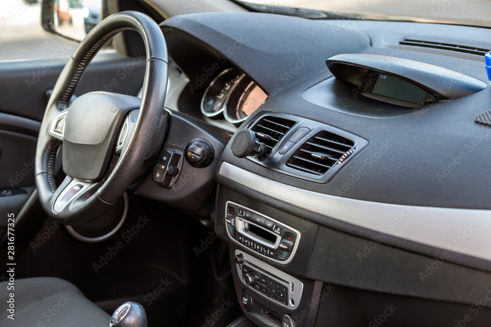 Modern expensive car interior. Dashboard and steering wheel in black color. Transportation, design, modern technology concept.