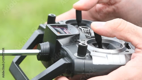 Piloting Radio controlled helicopter with remote control. Hands holding a transmitter