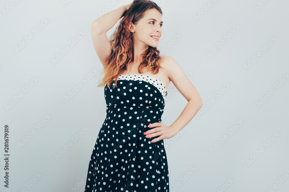 Portrait of beautiful young woman with ombre wavy hair. Pretty girl in retro dress dreamily looking aside posing on grey background. Portrait of beautiful young woman with ombre wavy hair. Pretty girl in retro dress dreamily looking aside posing on grey background.