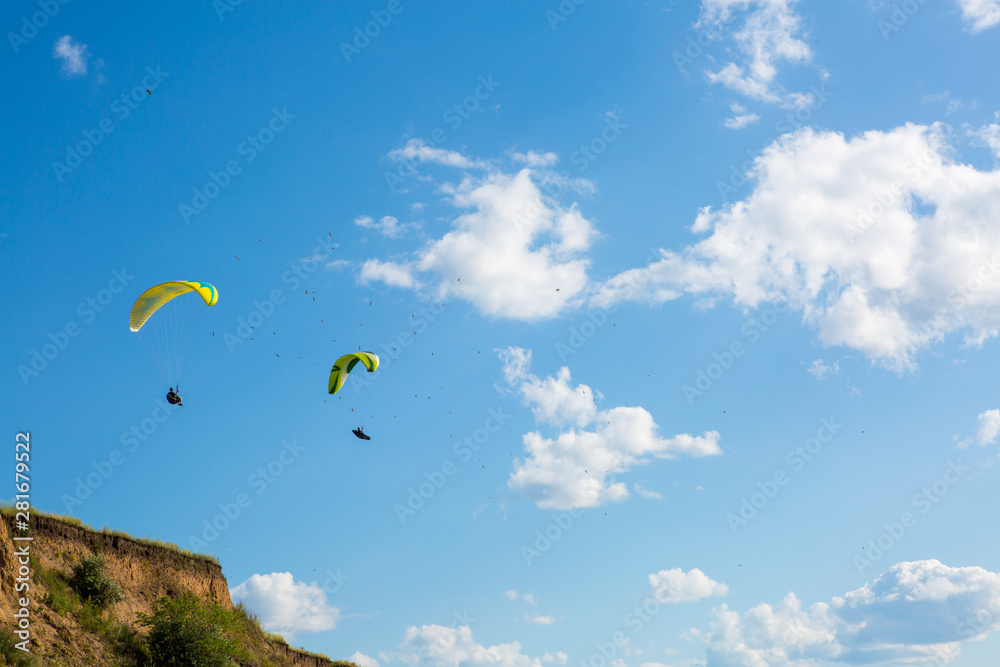 paraglider flying in the blue sky among the white clouds. Paragliding paraglider flying in the blue sky among the white clouds. Paragliding