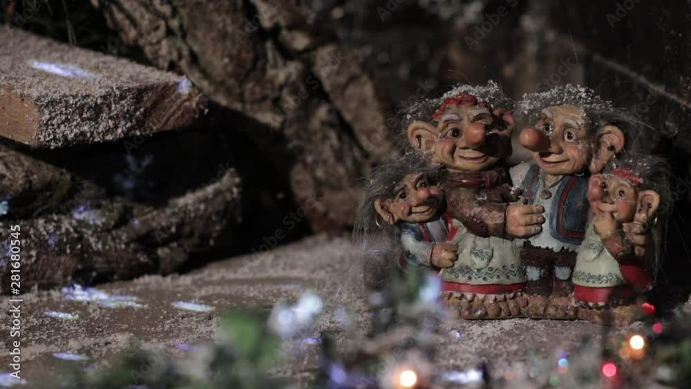 Fairytale family of elves and trolls on the background of a wooden house with blinking lights. Copy space. Fairytale family of elves and trolls on the background of a wooden house with blinking lights. Copy space.