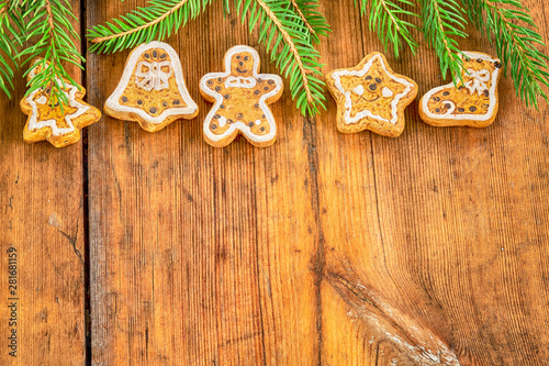 Christmas gingerbread cookies and twigs of Christmas tree on a wooden table