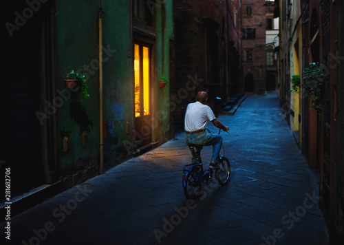 Wallpaper Mural Man cycling through Italian street at night Torontodigital.ca