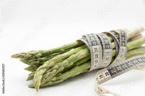 Asparagus surrounded by a medical tape on weighing scale for diets