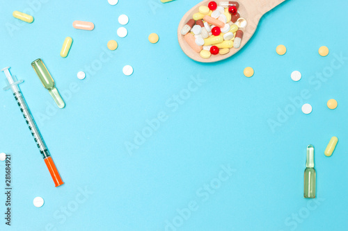 medicine pills, tablets and capsules on wooden spoon