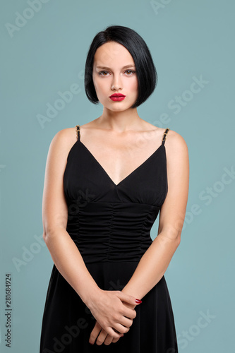 Beautiful girl with short dark hair and red lips posing in studio