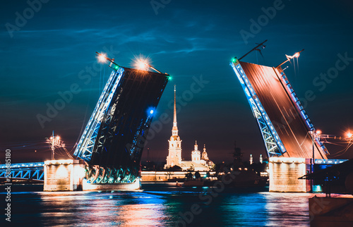 A famous illuminated drawbridge in Saint Petersburg at night with lights reflected in water. Trinity or Troitskiy bridge. Travelling to Russia well-known sight. Beautiful night river view. photo