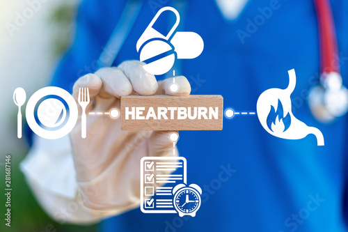 Heartburn Acid Reflux Disease Stomach Symptoms Health Care concept. Doctor hold wooden block with heartburn word and arround gastric icons. photo