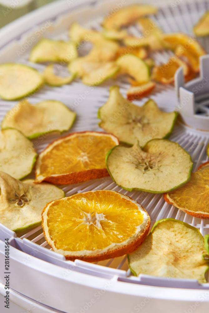 Apple and orange chips cooked in a dehydrator, the theme of healthy eating Apple and orange chips cooked in a dehydrator, the theme of healthy eating