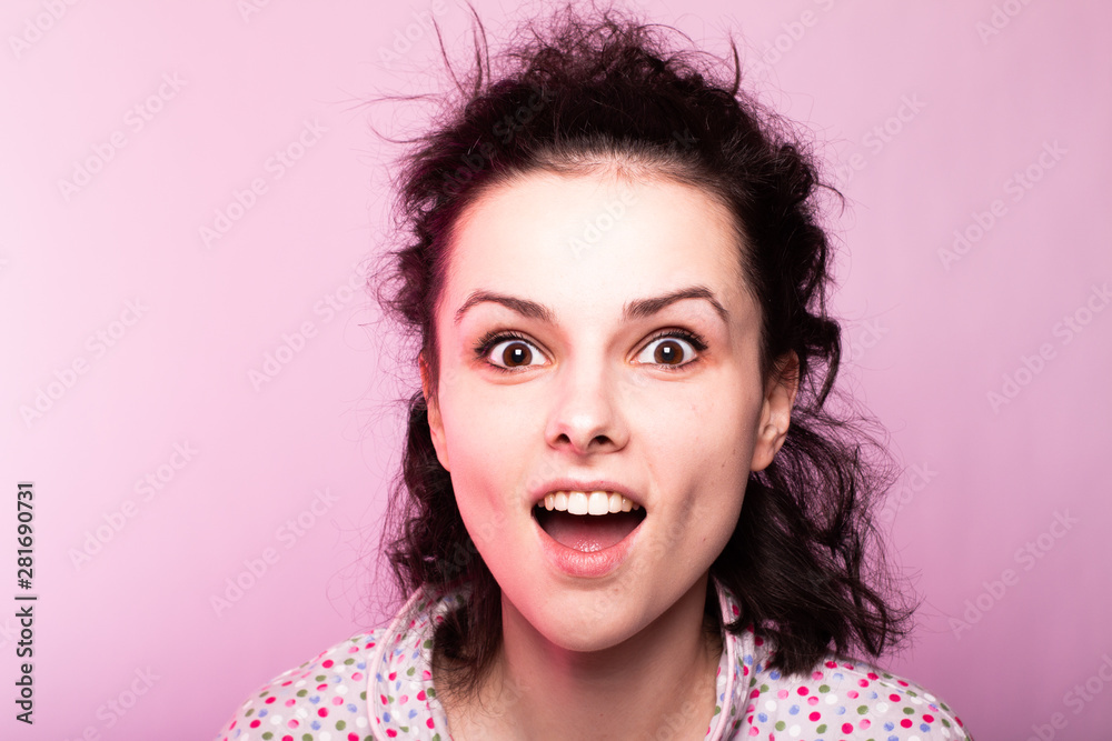 beautiful curly girl in pajamas, pink background