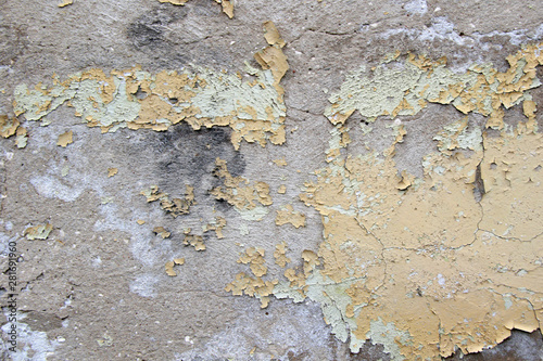 old cracked yellow green paint on the cement wall