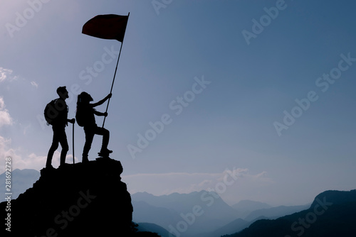 friend holding flag on top mountain. Conception of winner, success and leadership