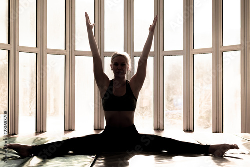Beautiful woman coach yoga practice. Yoga concept. Split pose, hands above head