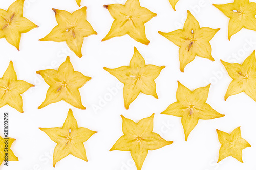 Ripe and exotic slices of star fruit scattered on a white background - Averrhoa carambola - Ripe Carambola