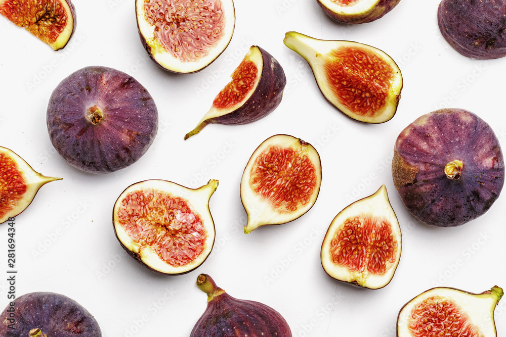 Whole and sliced ripe juicy figs on a white background. Top view. Whole and sliced ripe juicy figs on a white background. Top view.