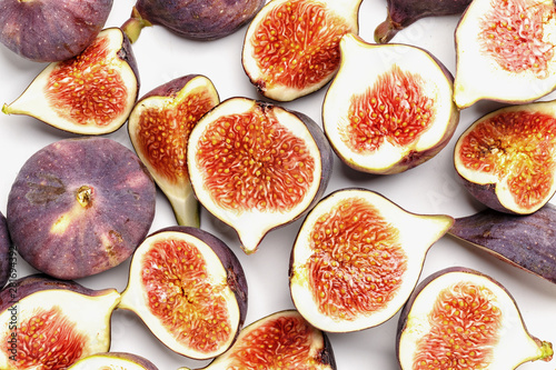 Whole and sliced ripe juicy figs on a white background. Top view.