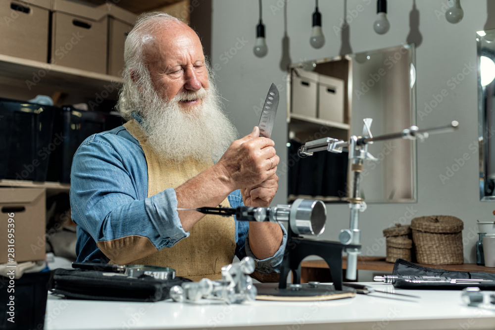 old man works, knife in a vise, knife sharpening Stock Photo | Adobe Stock