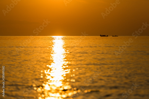 returning fishermen boat silhouette against orange sunrise on Lake Malawi  the sun glitter on the Lake  South-East-Africa