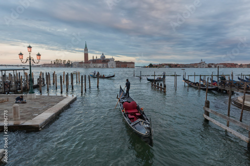 Gondolas in Venice at dusk taken on the shoreline besides the Piazza San Marco / St Marks Square.The image was taken during a dramatic sunset. © Joe