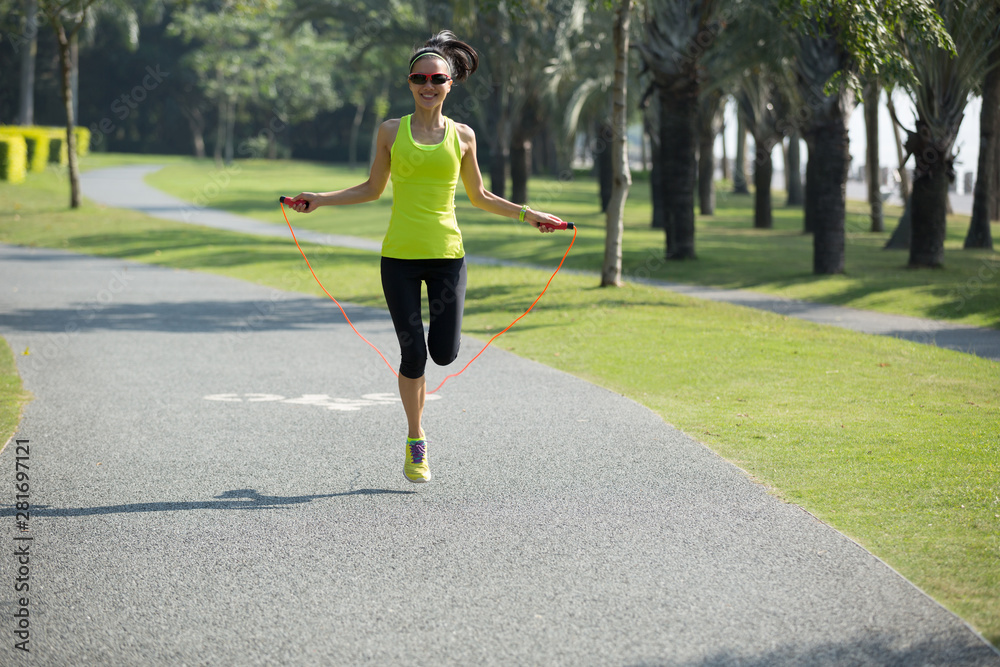 Young fitness woman jumping rope at tropical park Young fitness woman jumping rope at tropical park