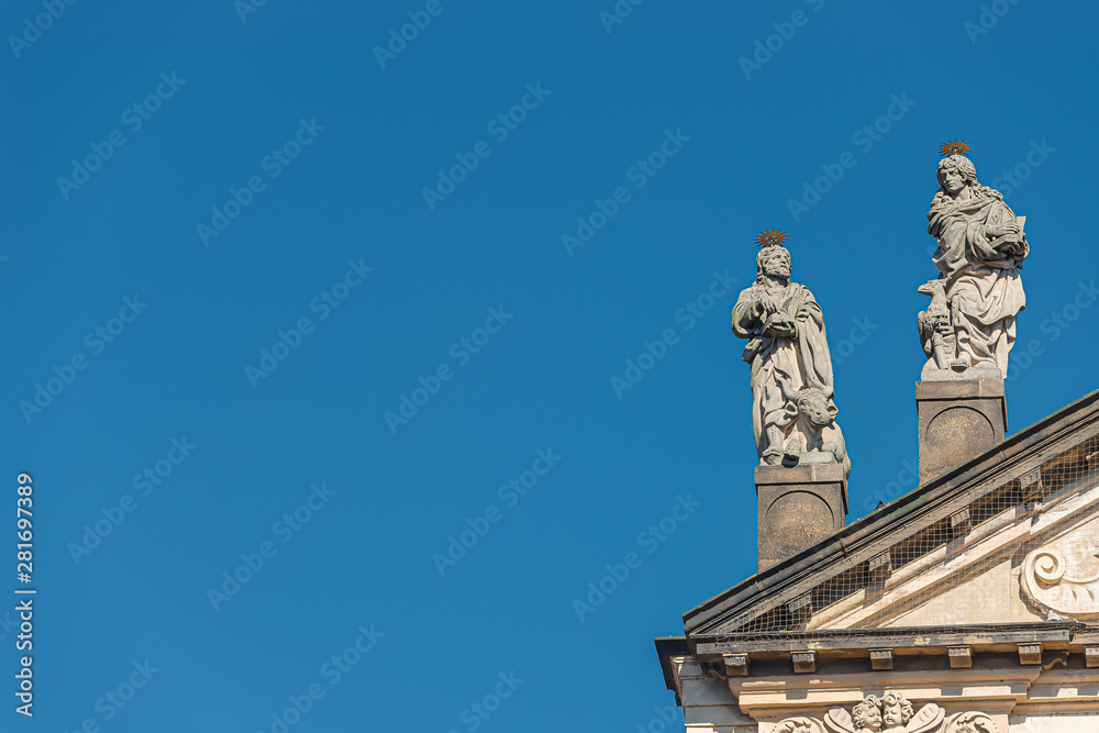 Decorative facade statues of priests and bishops at Saint Salvator church near Charles Bridge in Prague, Czech Republic, summer time, details