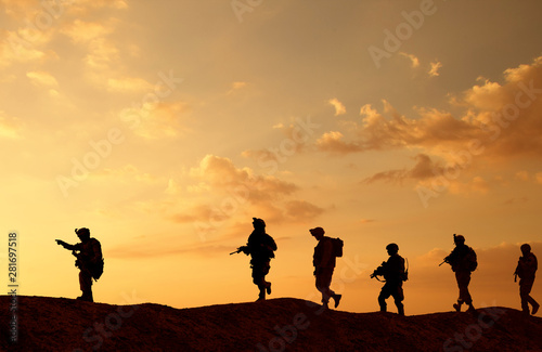 Military troops and helicopter on the way to the battlefield in sunset.