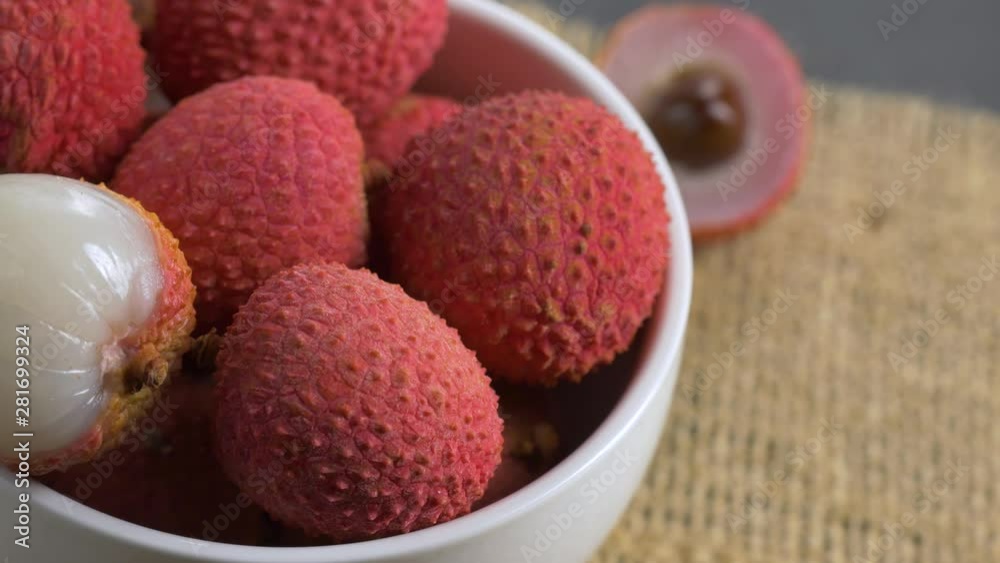 Rotating Fresh lychee in white bowl.