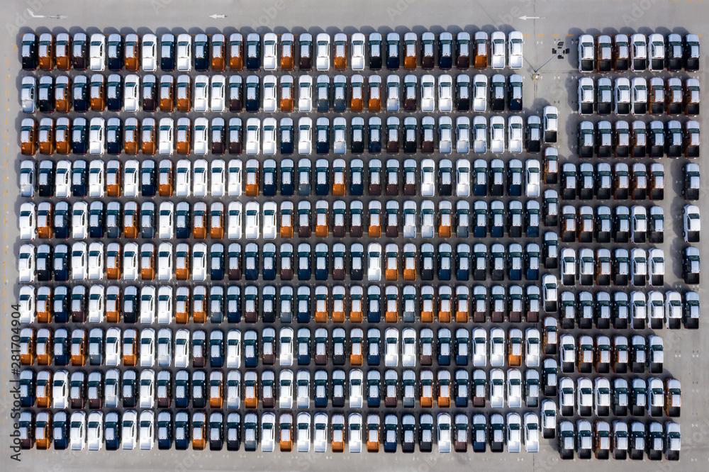 Aerial top view new cars lined up in the port for import export business logistic and transportation by ship in the open sea. New cars from the car factory parked at the port Aerial top view new cars lined up in the port for import export business logistic and transportation by ship in the open sea. New cars from the car factory parked at the port