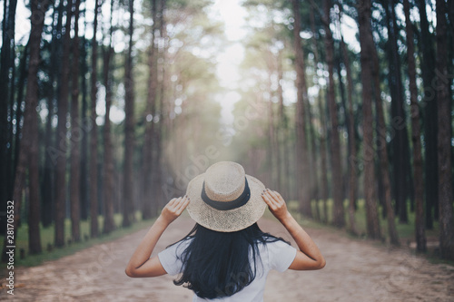 Traveler's concept Rear View Of woman traveler holding hat in Pine forest park Traveler's concept © anut21ng Stock