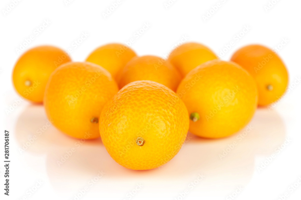 Lot of whole fresh orange kumquat arranged symmetrically isolated on white background Lot of whole fresh orange kumquat arranged symmetrically isolated on white background