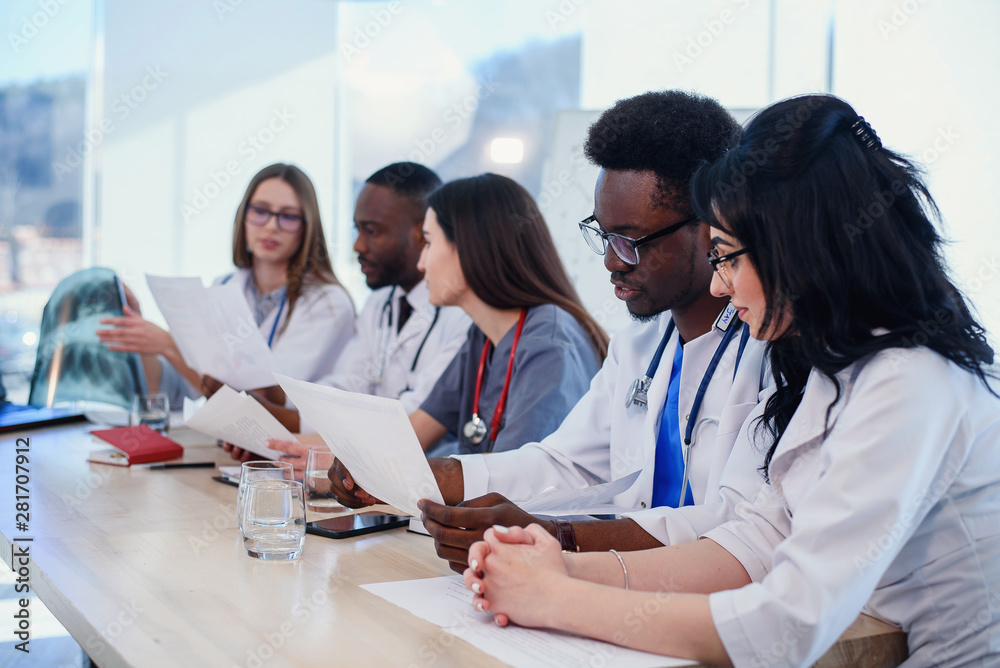 Fototapeta premium Team of professional doctors having a meeting in conference room at the modern hospital. Health care and medical developmant concept.