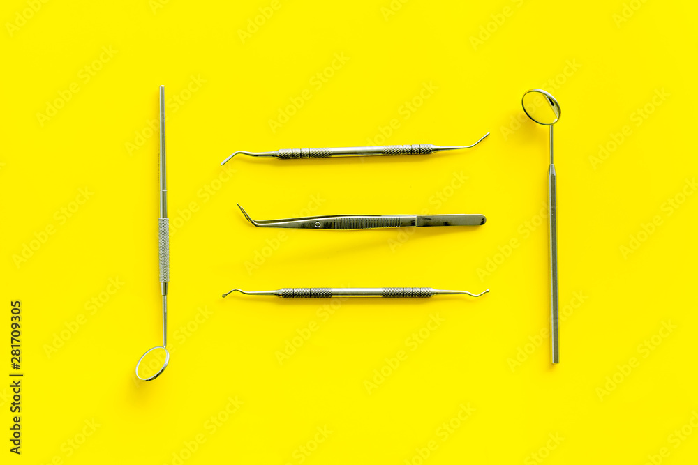 Dentist tools for cure teeth on yellow background top view Dentist tools for cure teeth on yellow background top view