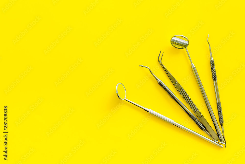 Dentist tools for cure teeth on yellow background top view copy space Dentist tools for cure teeth on yellow background top view copy space