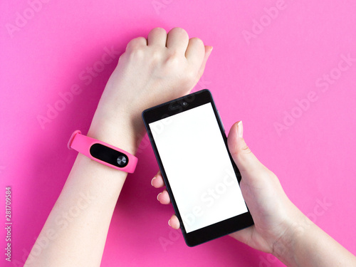 Wallpaper Mural Fitness tracker on a womans hand and smartphone on pink background. Torontodigital.ca