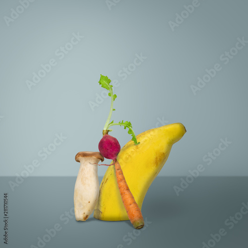 Creative of  fruits and vegetable. banana, radish, mushroom, and carrot, on blue background photo