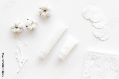 pattern of cosmetic cotton swabs, pads and cream on white background top view