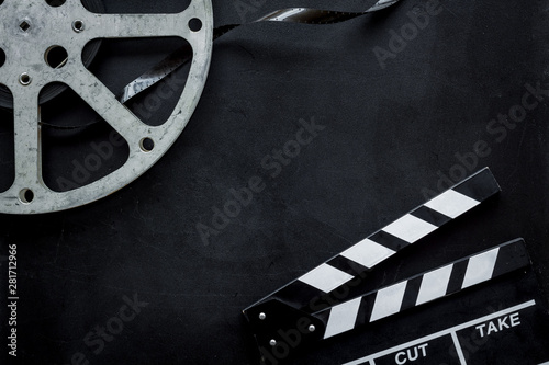 Go to the cinema with film type and clapperboard on black background top view mock up