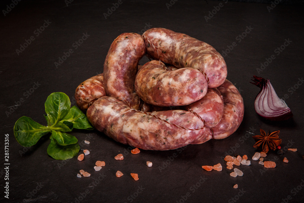 Fototapeta premium closeup homemade raw sausages with onion and basil