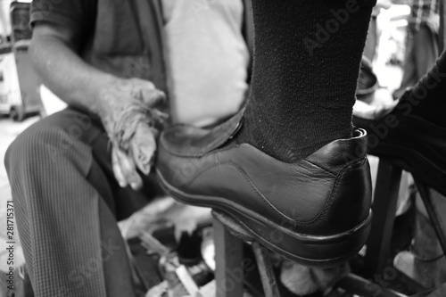 Man polishing shoe in the street