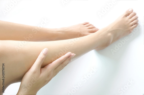 Beautiful female legs and feet on a white background. Concept beauty and hydration of the skin.