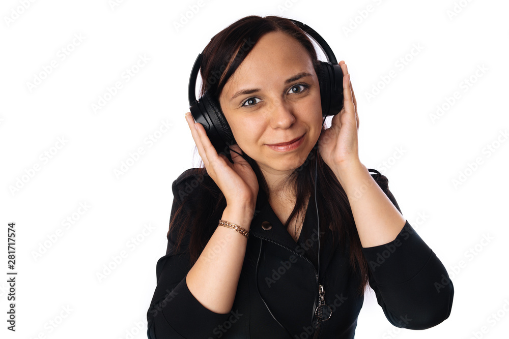 A beautiful young woman in headphones is dancing isolated on white background. The concept of International Music Day. A beautiful young woman in headphones is dancing isolated on white background. The concept of International Music Day.