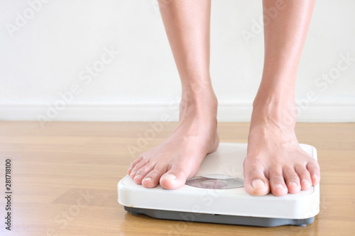 Legs of women standing on scales weight background fitness room. Concept of healthy lifestyle and sport