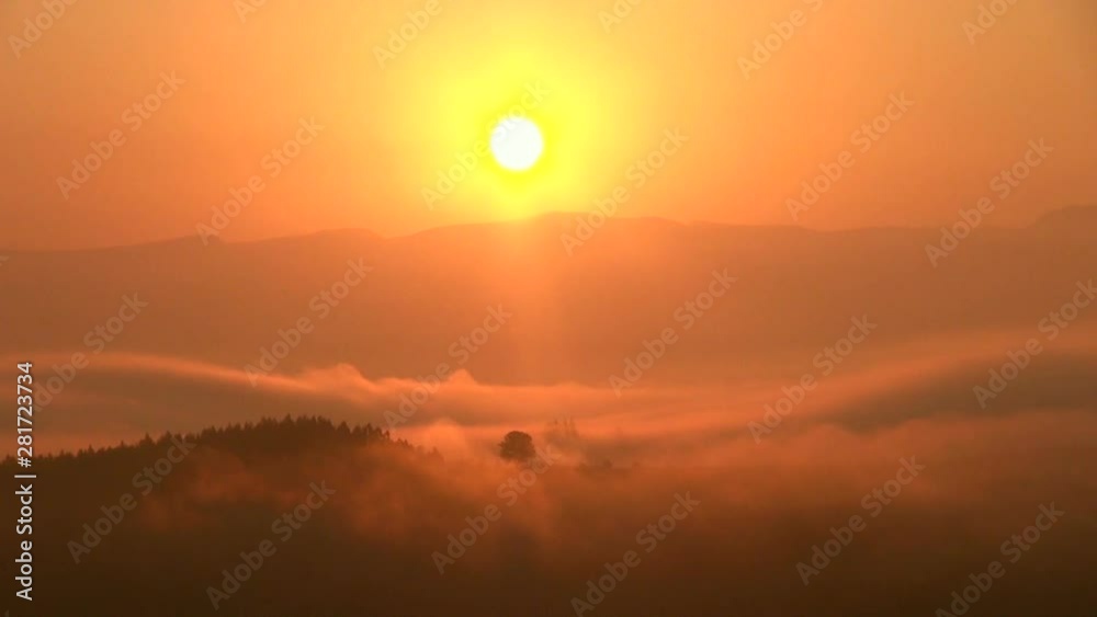 Timelapse of sun rising over hills shrouded in thick fog Timelapse of sun rising over hills shrouded in thick fog