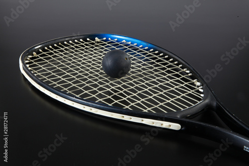 tennis racket with ball on black background