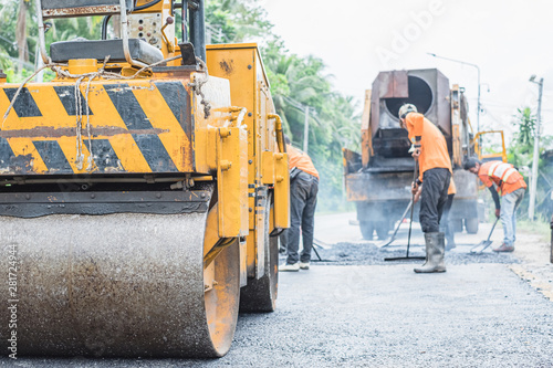 Fototapeta Naklejka Na Ścianę i Meble -  Small asphalt roller in on duty repairing repairing asphalt road. Workers on a road construction, industry and teamwork.