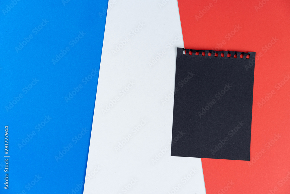 Plakat Blacklist France. Mourning, ban, sanctions, politics. black sheet from notebook lies on French flag. Mock up, copy space, pattern, cardboard texture.