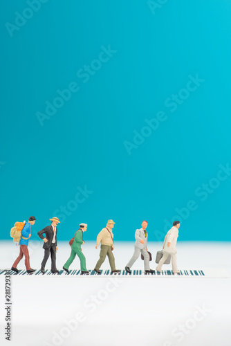 Miniature toys a group of people crossing a road - road safety concept.