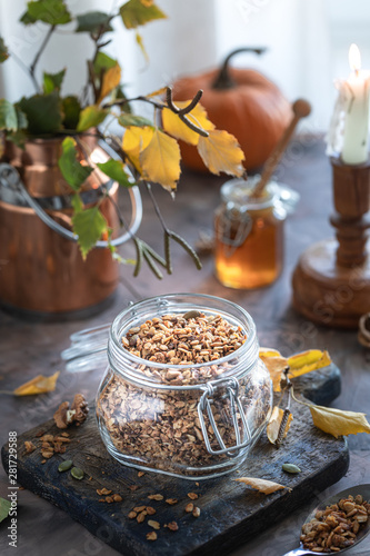 Homemade pumpkin muesli with nuts and seeds in a glass jar for a healthy breakfast. Autumn still life